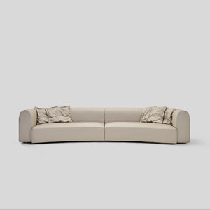 Genuine leather modern luxury curved sofa with hand-woven leather straps and plush cushions.  Rounded arms with, exposed thread details.