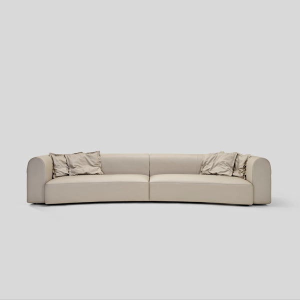 Genuine leather modern luxury curved sofa with hand-woven leather straps and plush cushions.  Rounded arms with, exposed thread details.
